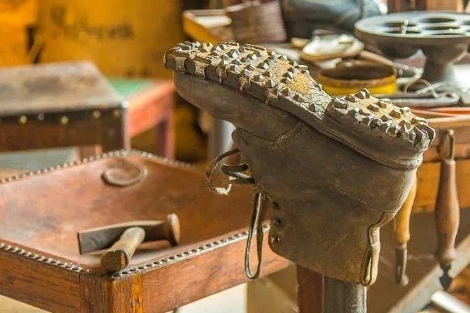 Bàn làm việc của thợ sửa giày với dụng cụ vá đồ da