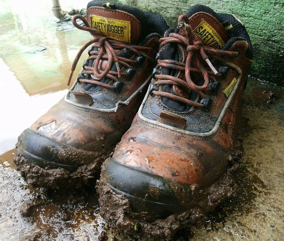 Đôi boots da dính đầy bùn sau khi đi ngoài đường đất ướt
