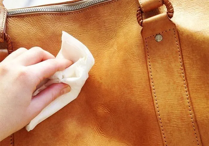 Inspecting a stored leather bag regularly for mildew along the stitching